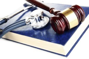 Medicine law concept. Gavel and stethoscope on book close up